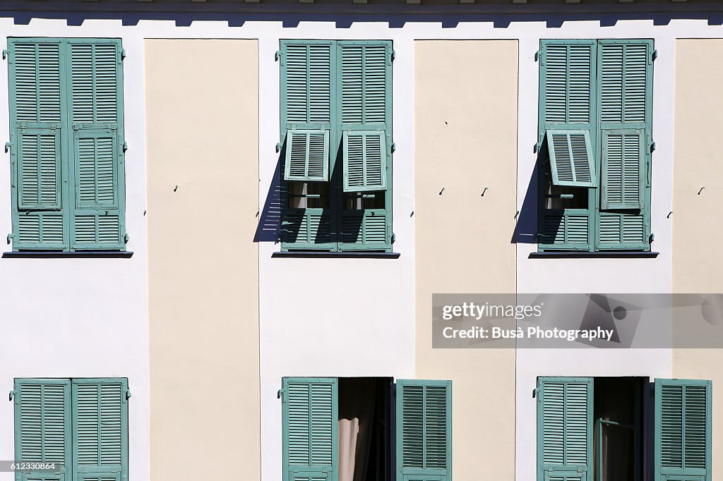 Green window shutters in old residential building in Nice, France