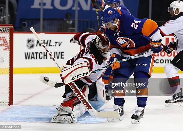 Cory Schneider of the New Jersey Devils makes a save against Stephen Gionta of the New York Islanders during their pre season game at Barclays Center...