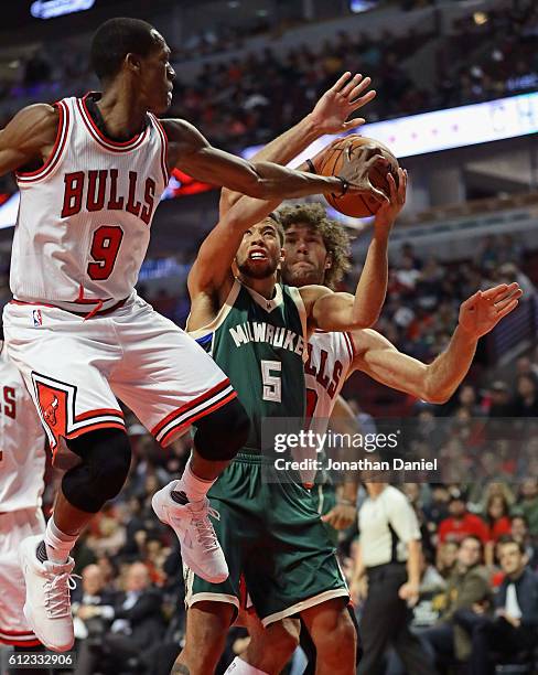 Rajon Rondo of the Chicago Bulls gets his hand on the ball as Michael Carter-Williams of the Milwaukee Bucks tries to shoot during a preseason game...