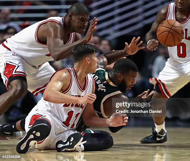 Greg Monroe of the Milwaukee Bucks passes the ball to a teammate surronded by Doug McDermott, Cristiano Felicio and Isaiah Canaan of the Chicago...