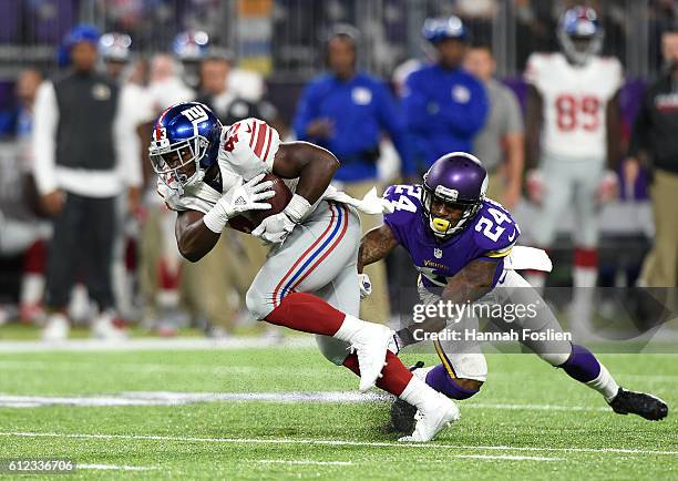 Bobby Rainey of the New York Giants carries the ball while pursued by Captain Munnerlyn of the Minnesota Vikings in the first half of the game on...