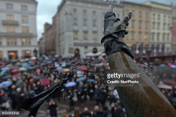 The hand from Adam Mickiewicz statue holds a hanger during a 'Black Monday' protest as Pro-Choice protesters gathered in Krakow Main Square, during a...