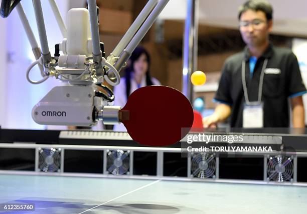 This photo taken on October 3, 2016 shows a table-tennis-playing robot developed by Omron hitting a return during a demonstration at a press preview...