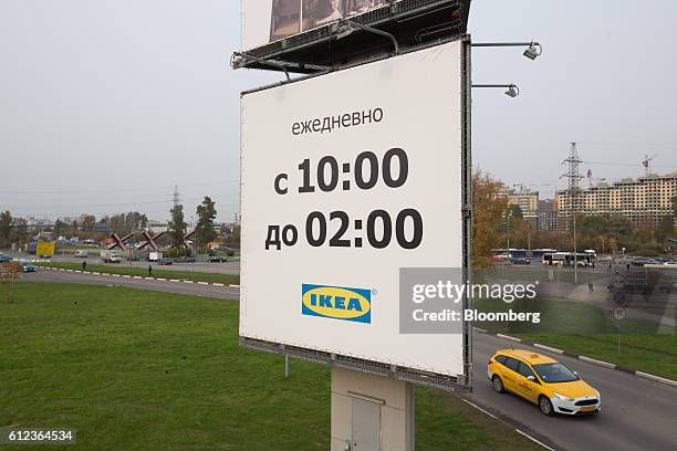 Yellow taxi passes a large sign advertising store opening times outside the Ikea AB retail store in Khimki, Russia, on Monday, Oct. 3, 2016. Ikea's...