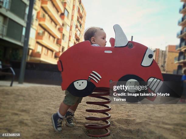 baby boy behind wood car at the playground - chert 個照片及圖片檔