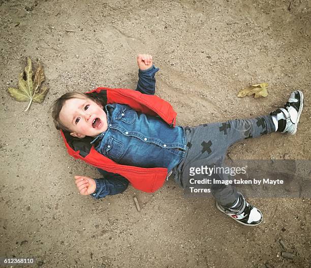 boy having a tantrum - ropa tirada en el suelo fotografías e imágenes de stock
