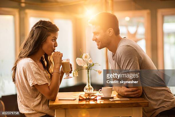 young couple in love spending time together in a cafe. - flirting 個照片及圖片檔