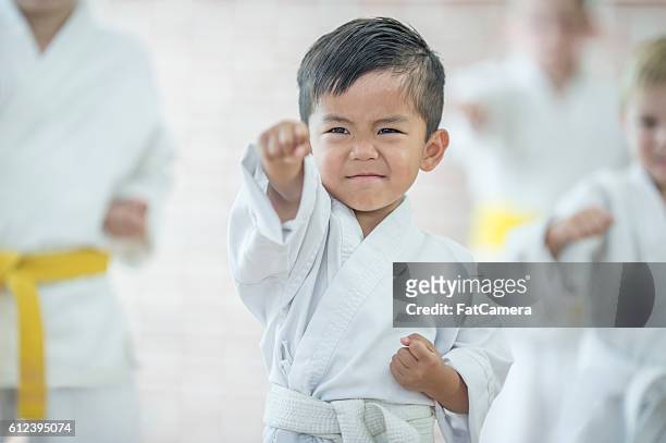 mignon petit garçon prenant du karaté - arts martiaux photos et images de collection