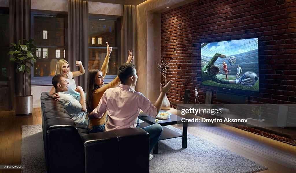 Paare jubeln und schauen Fußballspiel im Fernsehen