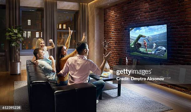 couples cheering and watching soccer game on tv - watch stock pictures, royalty-free photos & images