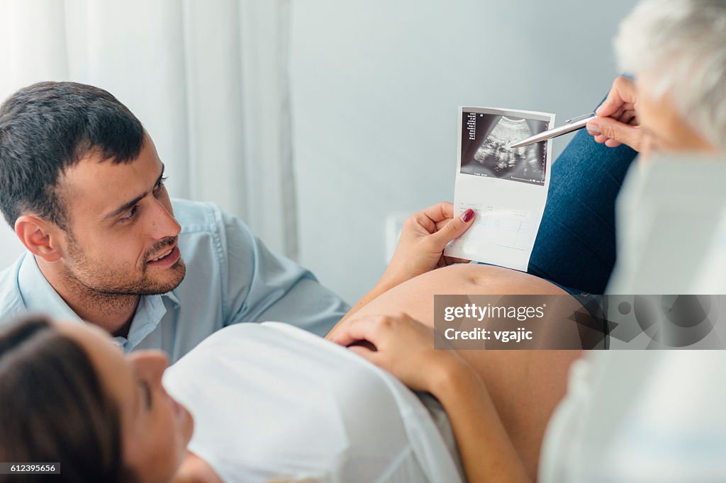 Jeune famille avec femme médecin en consultation.