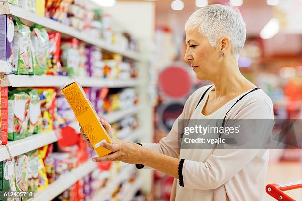 mature donna generi alimentari shopping. - cereali da colazione foto e immagini stock