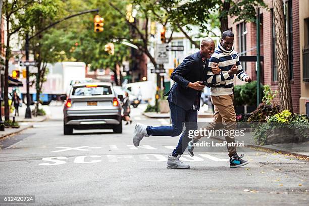 pareja de hombres cruzando la calle ciudad de nueva york - greenwich village fotografías e imágenes de stock