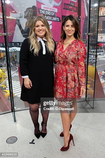 Kelly Clarkson and Hilaria Baldwin pose on the set of "Extra" at their New York studios at H&M in Times Square on October 4, 2016 in New York City.