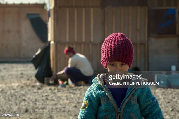 Child poses at the Grande-Synthe camp for migrants and refugees in northern France on October 4, 2016.