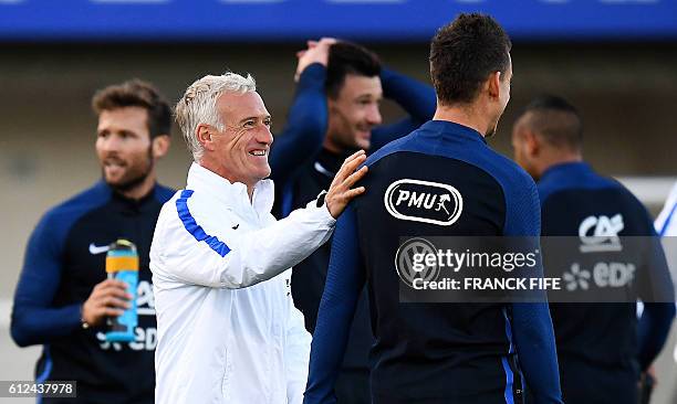 France's coach Didier Deschamps speaks to France's defender Laurent Koscielny during a training session in Clairefontaine-en-Yvelines near Paris on...
