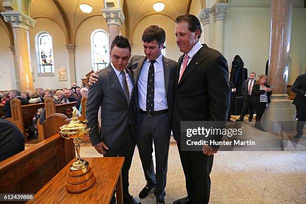 Ricky Fowler, Bubba Watson and Phil Mickelson embrace after putting the Ryder Cup on display during a Celebration of Arnold Palmer at Saint Vincent...