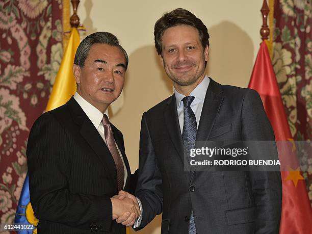 China's Foreign Minister Wang Yi and his Ecuadorean counterpart Guillaume Long shake hands during a meeting in Quito, on October 4, 2016. Wang Yi is...