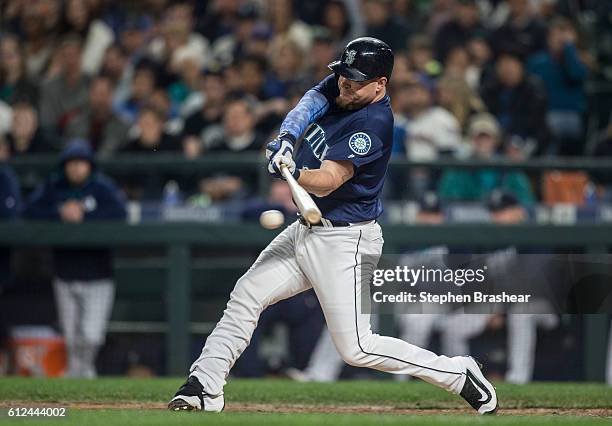 Adam Lind of the Seattle Mariners makes contact with the ball during an at-bat in a game against the Oakland Athletics at Safeco Field on September...