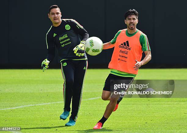 Mexico's football players Moises Muñoz and Oribe Peralta take part in a training session in Mexico City on October 4, 2016 ahead of the upcoming...