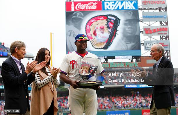 Ryan Howard of the Philadelphia Phillies and his wife Krystle accepts a hand painted first baseman's glove from Phillies owner John Middleton, left,...