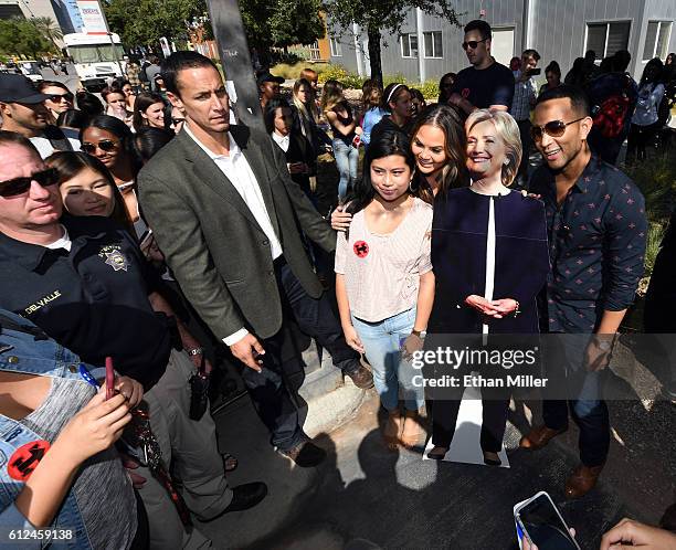 Model and television personality Chrissy Teigen and singer/songwriter John Legend pose with a cardboard cutout of Democratic presidential nominee...