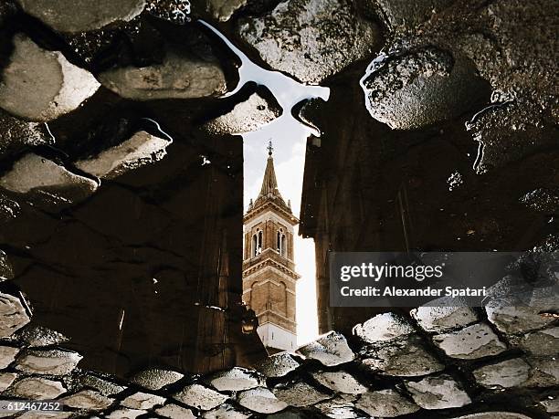 reflection of the church in puddle, rome, italy - atheism stock-fotos und bilder