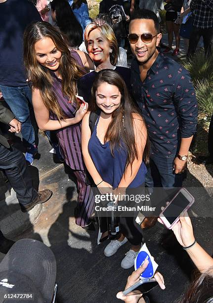 Model and television personality Chrissy Teigen and singer/songwriter John Legend pose with a cardboard cutout of Democratic presidential nominee...