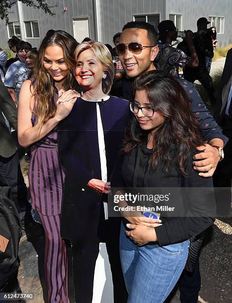 Model and television personality Chrissy Teigen and singer/songwriter John Legend pose with a cardboard cutout of Democratic presidential nominee...