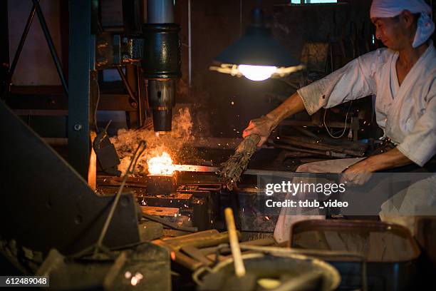 japanese blacksmith pounds red hot steel while forging a sword - samurai stock pictures, royalty-free photos & images