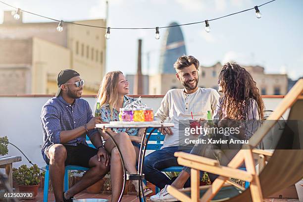 group of friends having a drink at rooftop party - beer friends imagens e fotografias de stock