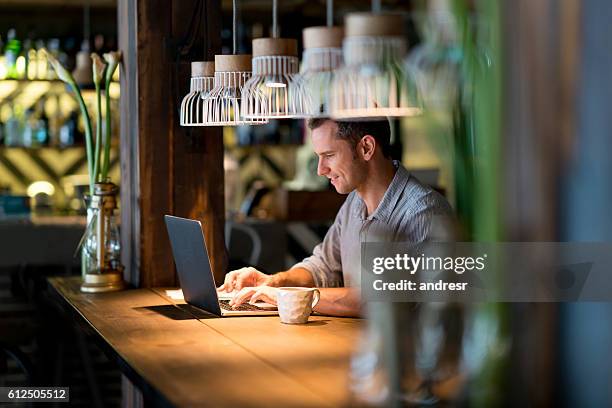 business-mann arbeitet in einem café  - businessman working on a laptop with a coffee stock-fotos und bilder