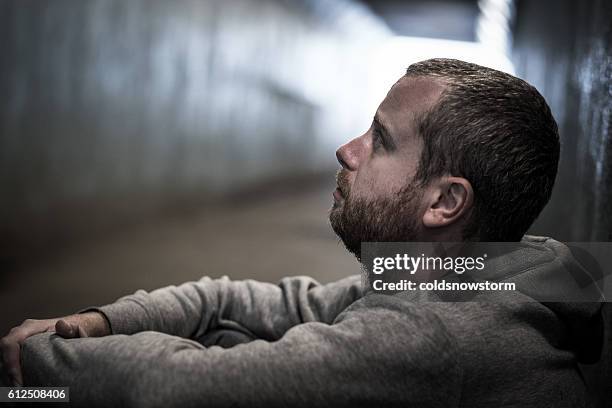 homeless adult male sitting in subway tunnel begging for money - drug abuse stock pictures, royalty-free photos & images