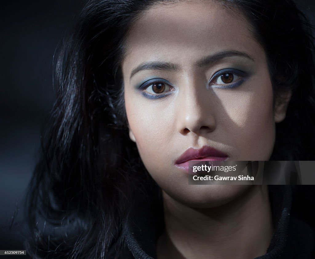 Beautiful serene young woman looking at camera with blank expression.