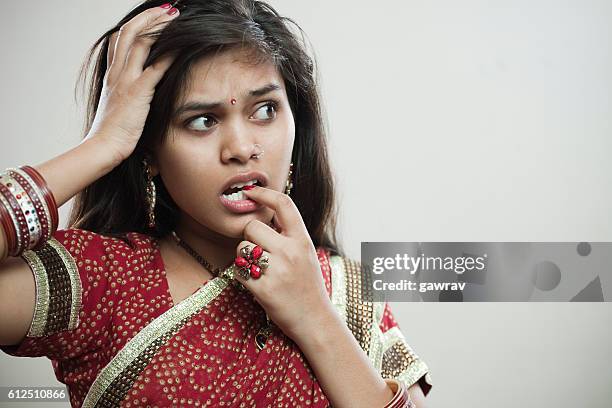 cute asian young woman biting her fingernail and looking away. - sari isolated stock pictures, royalty-free photos & images