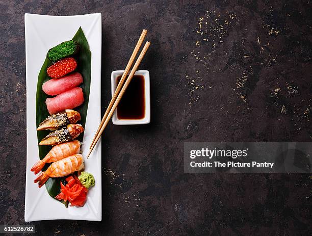 nigiri and gunkan sushi set on white plate on dark background copy space - gunkanmaki stock-fotos und bilder