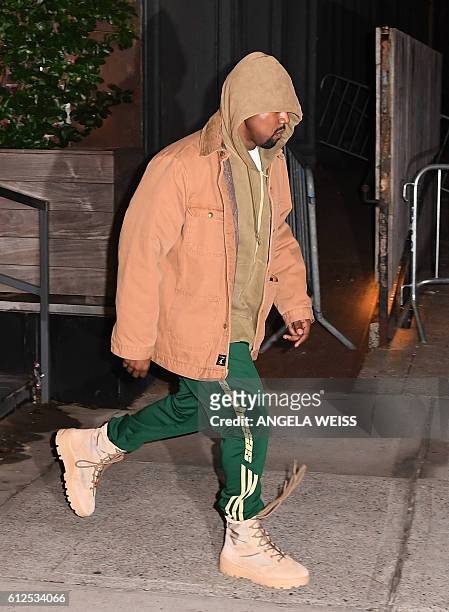 Kanye West leaves his apartment in New York on October 4, 2016. Kim Kardashian freed herself and raised the alarm after being tied up and robbed at...
