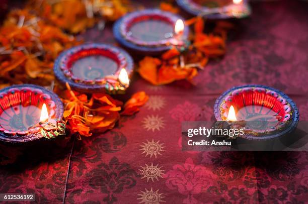 colorful clay diya lamps lit during diwali celebration with flowers - diwali 個照片及圖片檔