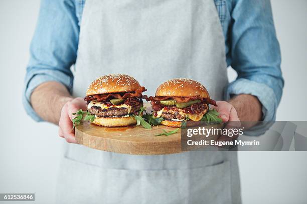 man holding homemade angus beef burgers with bacon whisky jam - burgers stockfoto's en -beelden