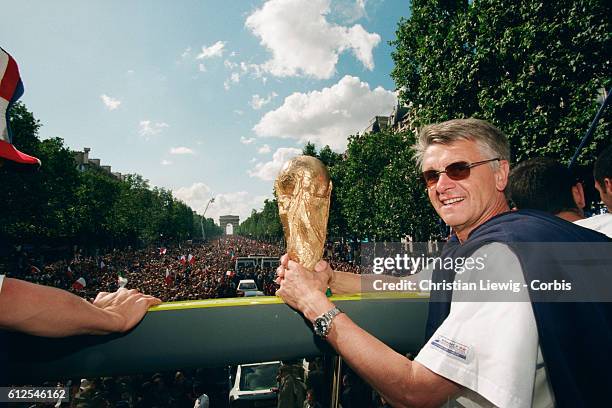 France's head coach Aime Jacquet of France's 1998 FIFA World Cup squad with the team's trophy during a parade on the Champs Elysees celebrating their...