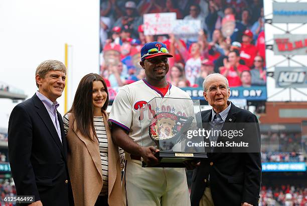 Ryan Howard of the Philadelphia Phillies and his wife Krystle accepts a hand painted first baseman's glove from Phillies owner John Middleton, left,...