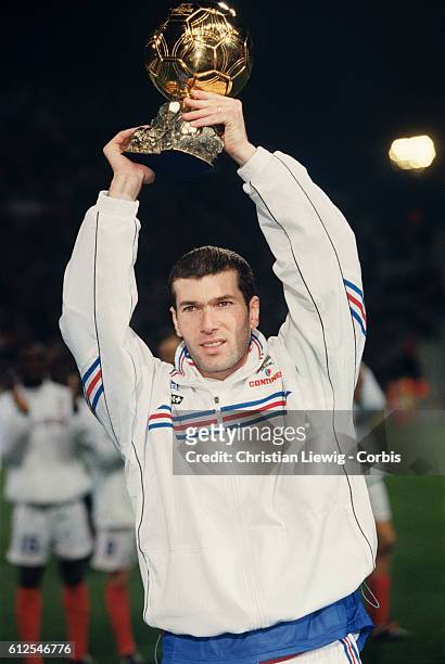 French soccer player Zinedine Zidane holding the European "Ballon d'Or" he was awarded in 1998.