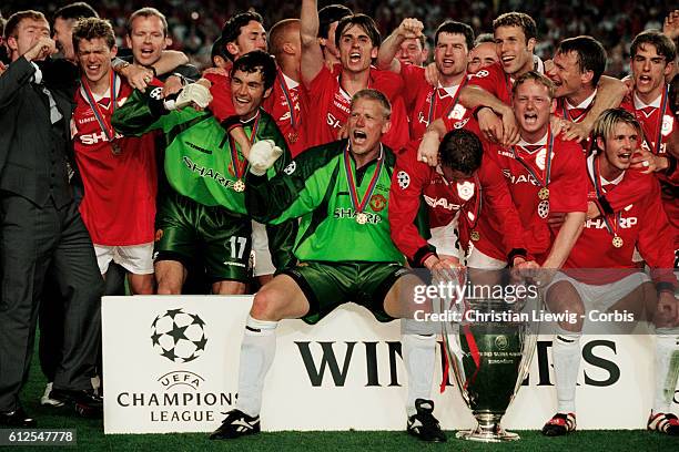 Manchester players celebrate with trophy after winning the 1997-1998 UEFA Champions League against Bayern Munich. | Location: Barcelona, Spain.