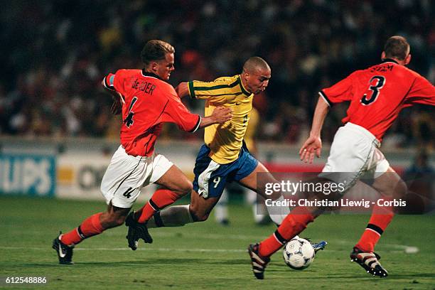 Brazilian player Ronaldo between Franck de Boer and Jaap Stam of the Netherlands during the semi-finals of the 1998 FIFA World Cup, Brazil vs...