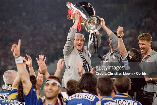 Juventus coach Marcello Lippi holds the trophy after his team won the 1996 UEFA Champions League final against Ajax Amsterdam. 1-1 4-2 .