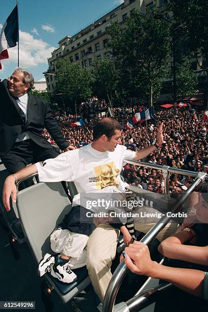 Zinedine Zidane of France's 1998 FIFA World Cup squad with his son Enzo during a parade on the Champs Elysees celebrating the team's 3-0 victory over...