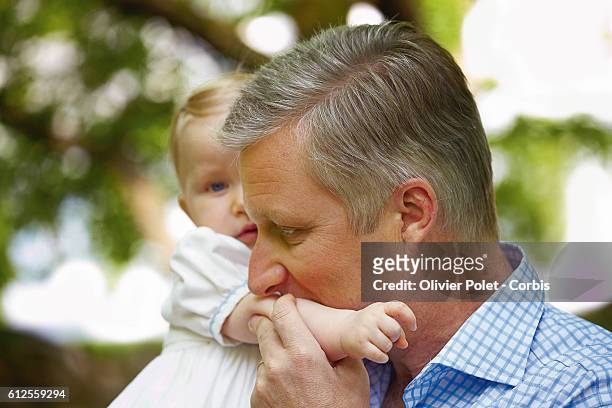 Prince Philippe kisses his daughter Princess Eleonore on the arm in the garden of the royal castle of Laeken.