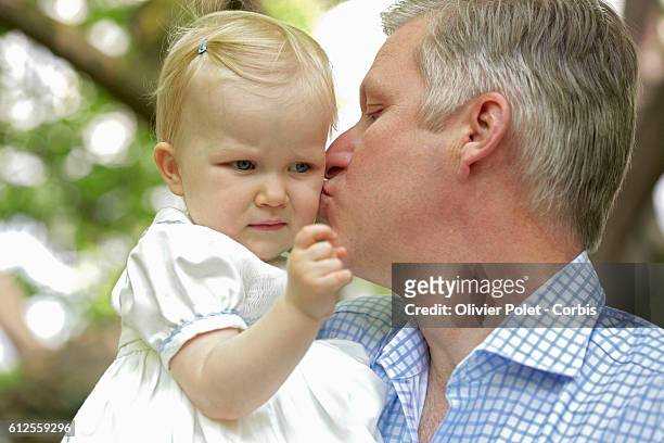 Prince Philippe kisses his daughter Princess Eleonore on the cheek in the garden of the royal castle of Laeken.