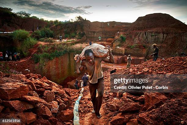 Miner carries bags filled with excess earth 28 March 2013 to clear the concession and expose the diamond-rich layers near an Angolan village not far...