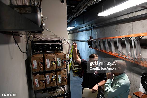 Denver fire protection engineer J.D. Lanz reads a gauge as he explains to Racines Restaurant owner David Racine why there will be new sensors, lights...